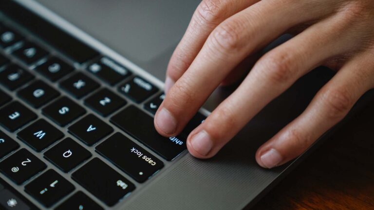 Hands typing on a laptop keyboard