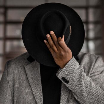 Man looking down holding hat