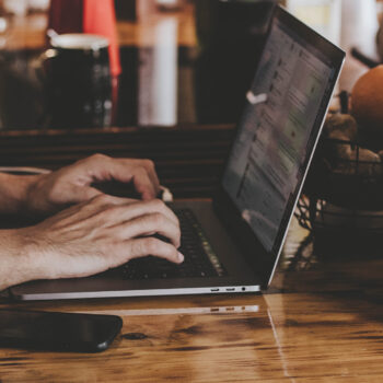 person on laptop sitting on brown table