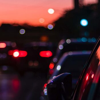 Busy street with cars driving by at dusk.