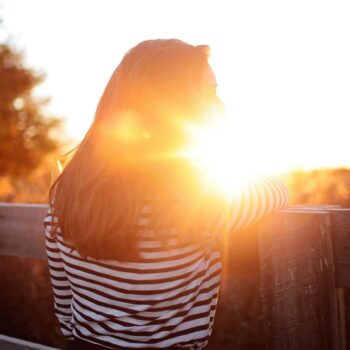 Brunette woman in front of sun