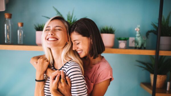 A young couple hugging and smiling in their home.