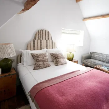 Bedroom with pink throw blanket on bed in airbnb rental house