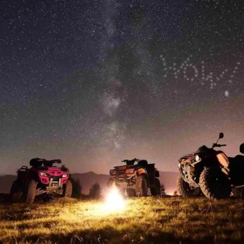 three atvs around a campfire at night