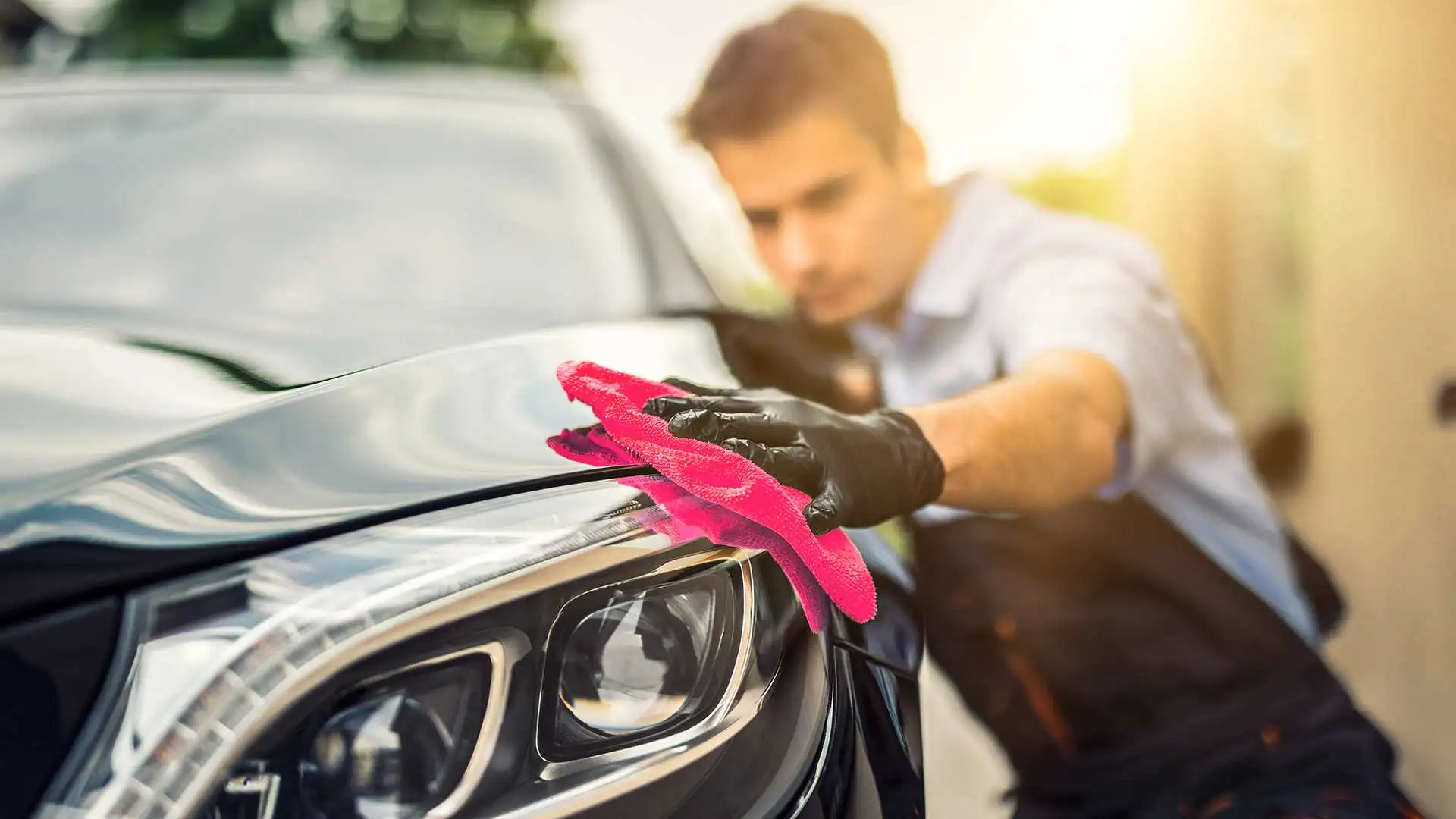 auto detailer wiping down car hood with cloth