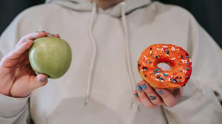 holding up apple and donut