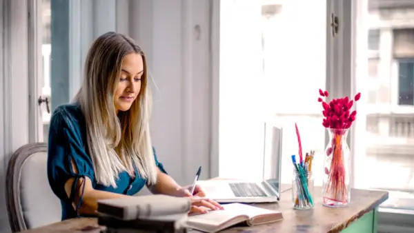 Woman working at desk of home office.