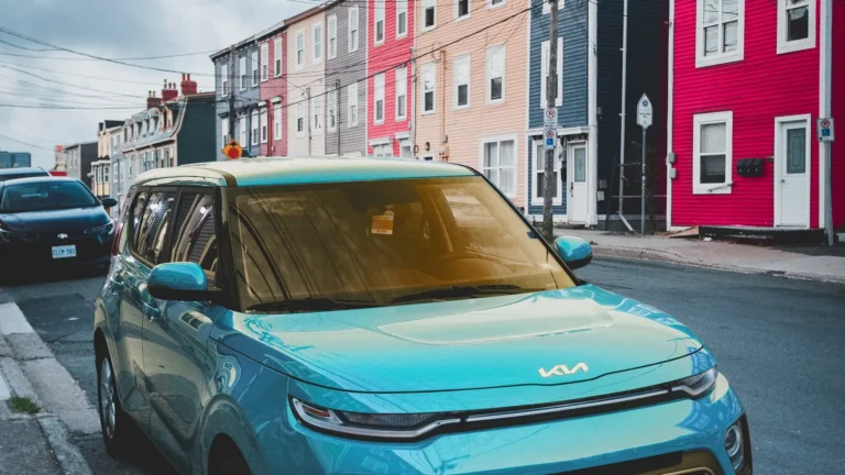 blue car parked on road in front of row houses