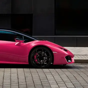 Pink luxury sports car on an empty urban street.