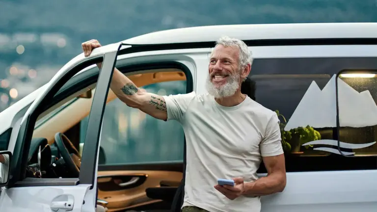 Older man standing outside his car.