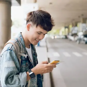 Person at airport ordering rideshare from their smartphone.