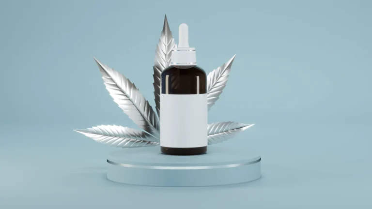 tincture bottle on glass riser with silver cannabis leaf behind