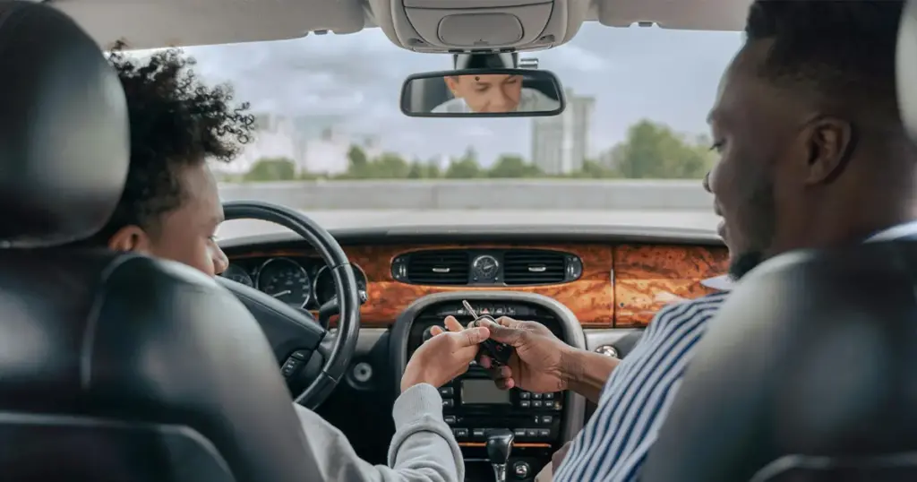 Father giving his car keys to his teenage son.