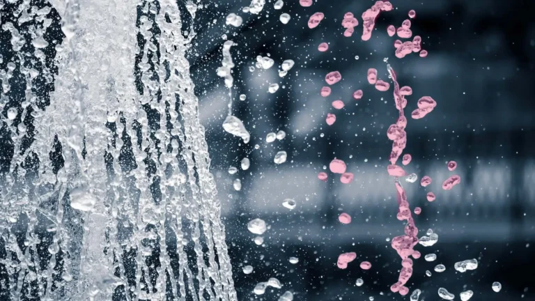 closeup on water flowing out of faucet with water droplets