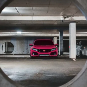 pink car in parking spot in parking garage