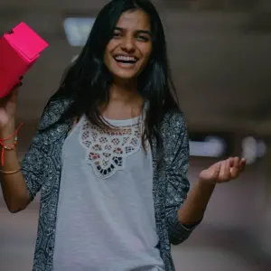 Smiling woman holding a box.