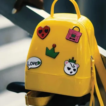 yellow backpack with five stickers on stair rail