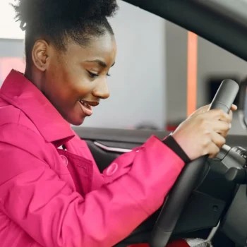 young female behind steering wheel of vehicle